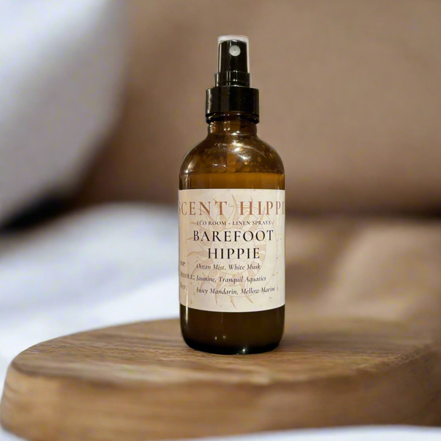 a brown spray bottle labeled "barefoot hippie" sitting on a wooden slab in a white bedroom.